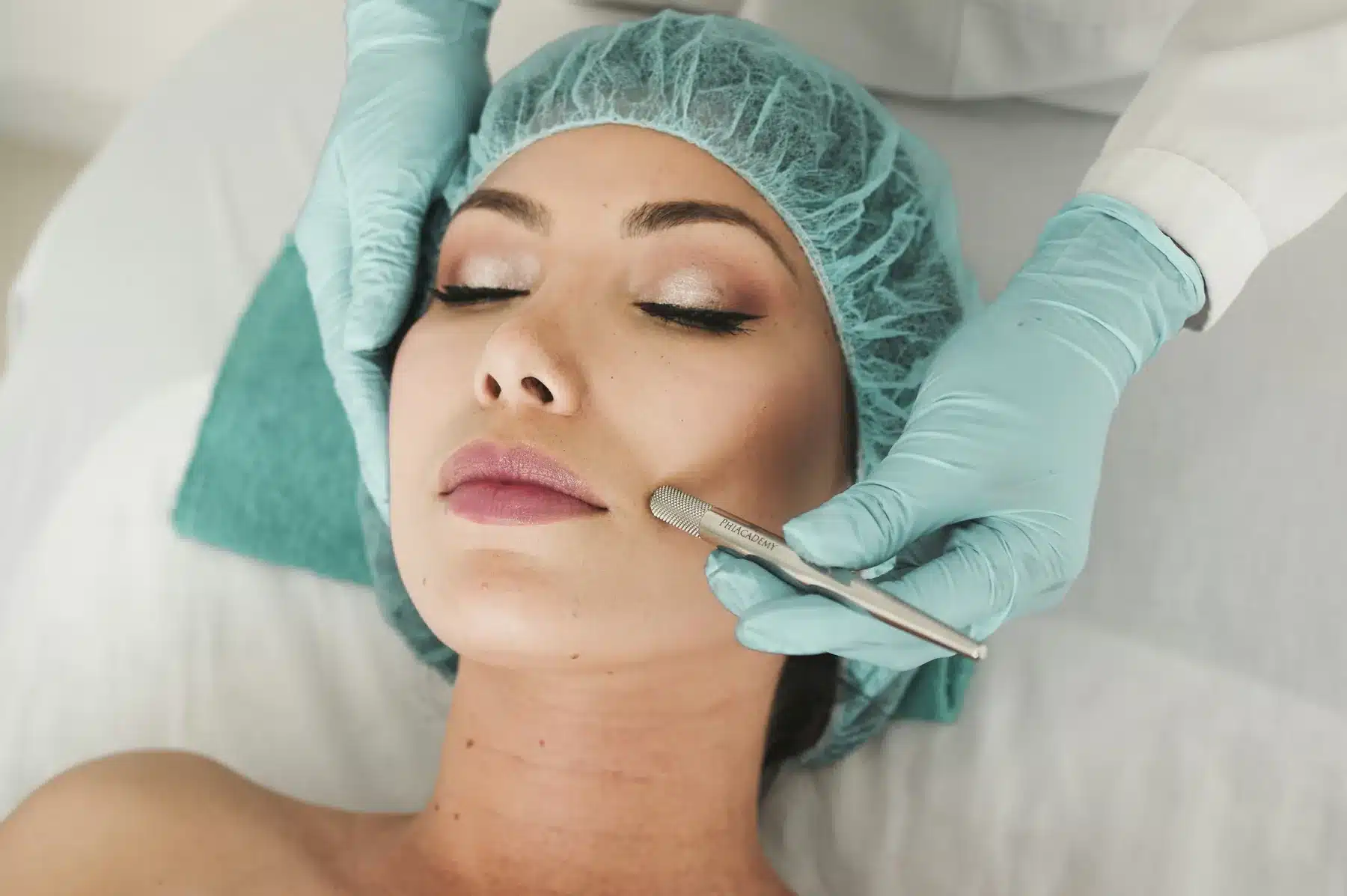 Dermaplaning facial in progress, with gloved hands smoothing the cheek, offered at Cosmetiq Medicine in Vancouver, WA