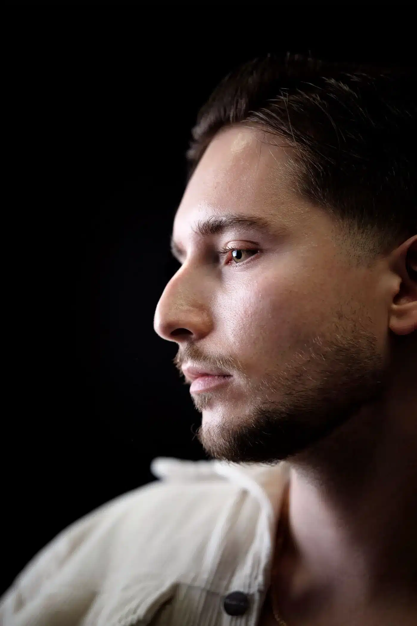 Man in profile with a defined jawline in a dark studio