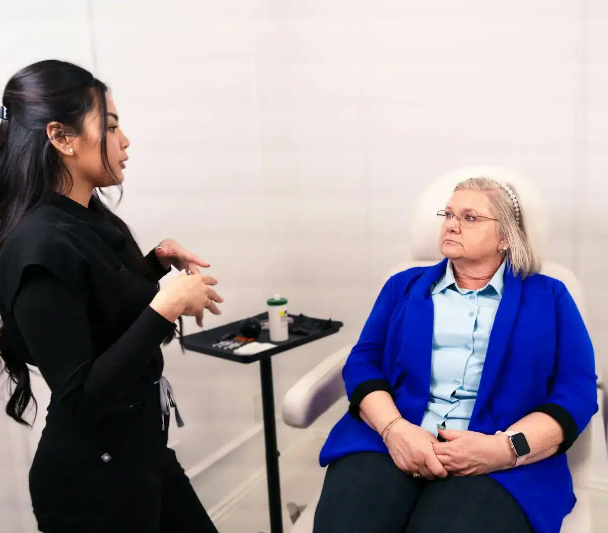 Consultation at a med spa, with a team member talking through treatment options with a seated client