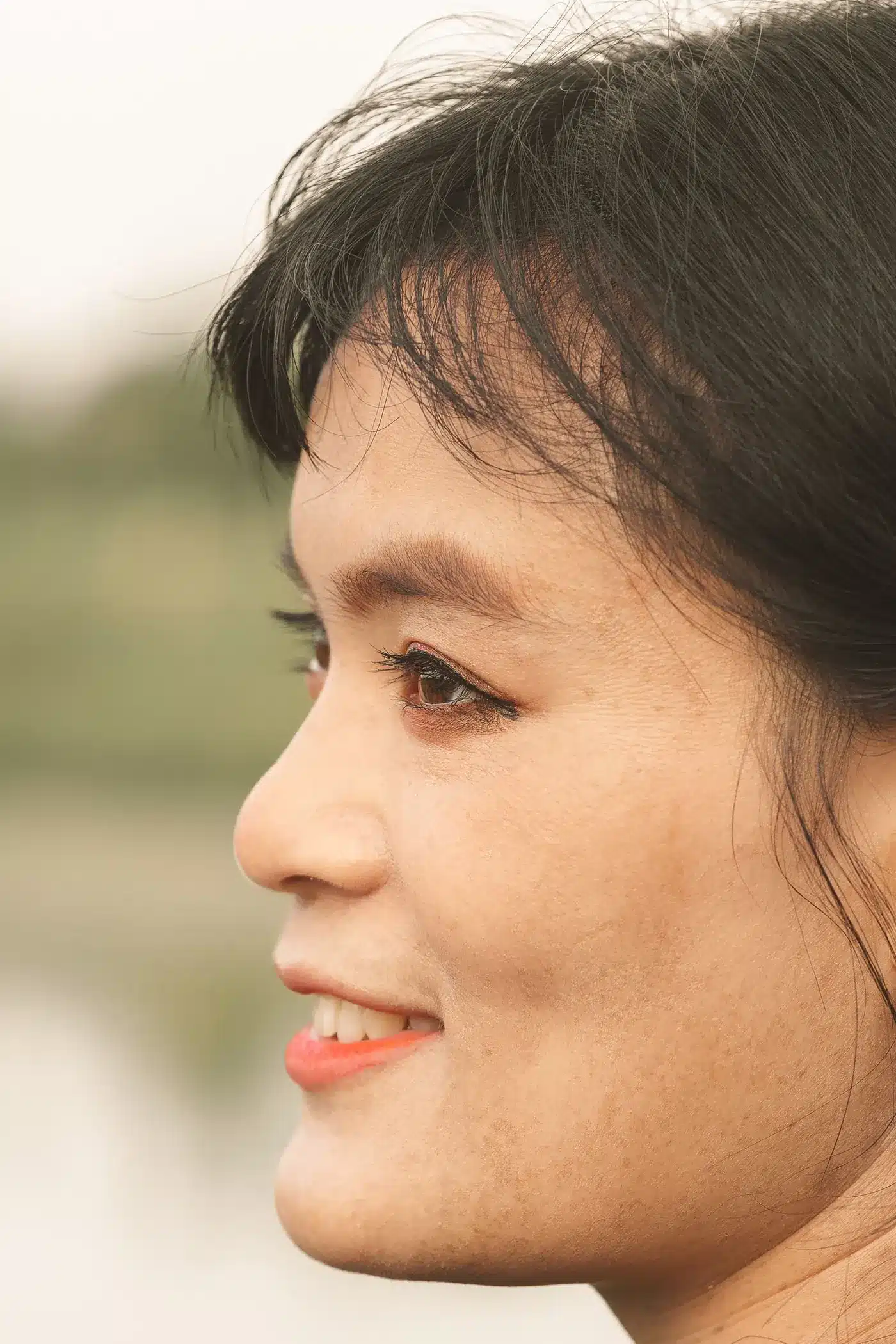 Smiling woman in profile with natural, firm-looking skin