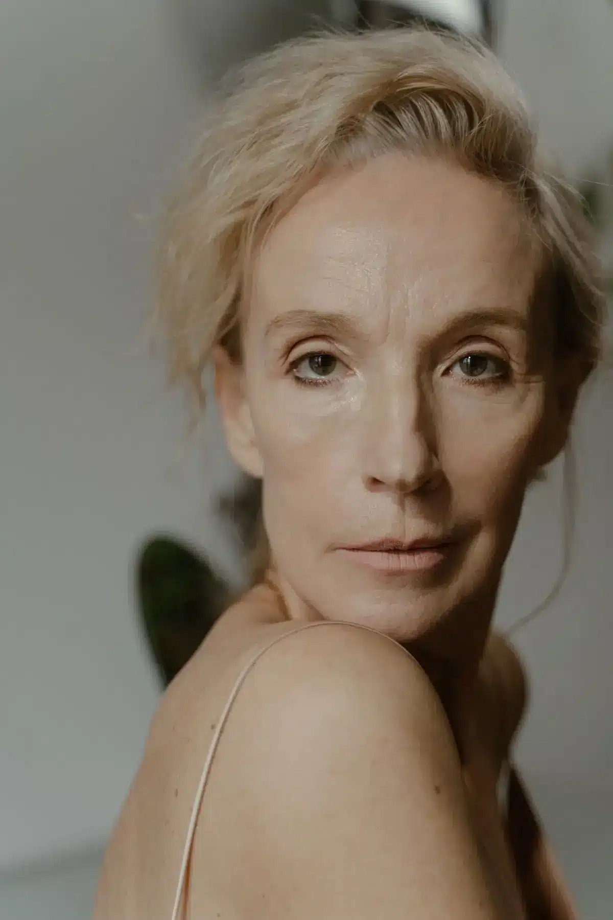 Woman with natural-looking skin in soft window light, Sculptra plans in Portland and Vancouver, WA